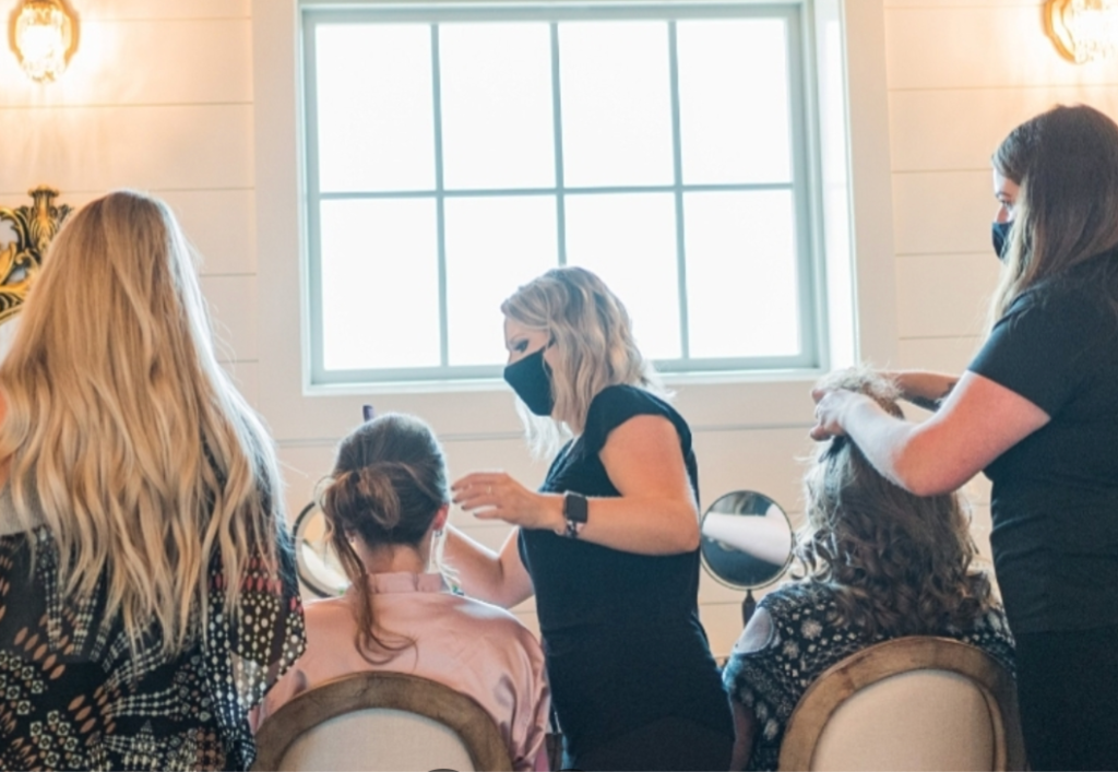 A group of women enjoying a hair salon experience, each getting their hair styled by professionals.